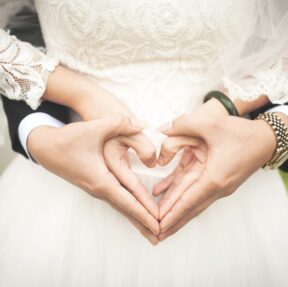 midsection-of-woman-making-heart-shape-with-hands-256737